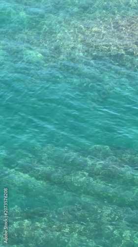 Blue sea gentle waves aerial view, vertical video.