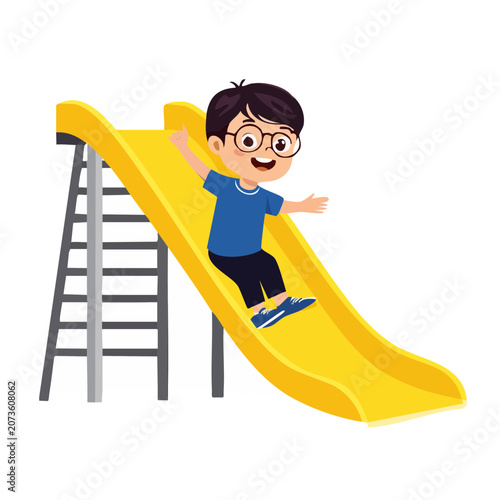 Happy boy sliding down yellow playground slide