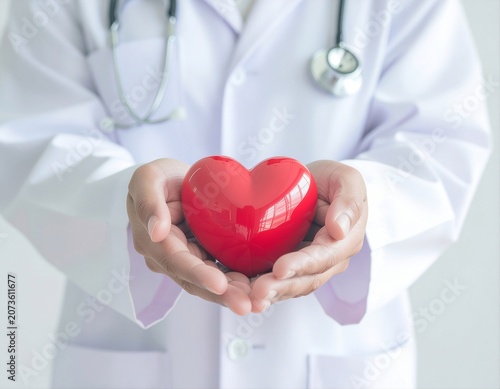 Doctor holding a red heart in caring hands, symbolizing healthcare, cardiology, medical support, compassion, heart health, and patient care.