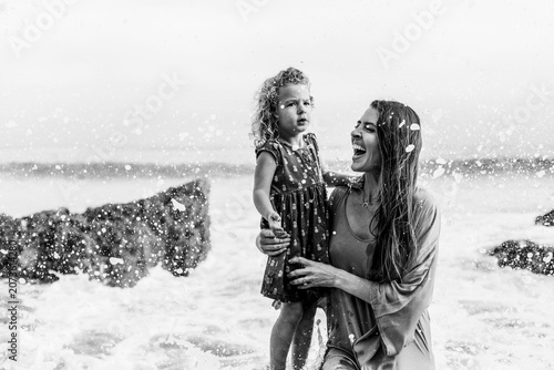 Tableau sur toile Joyful mother and daughter at the beach in black and white