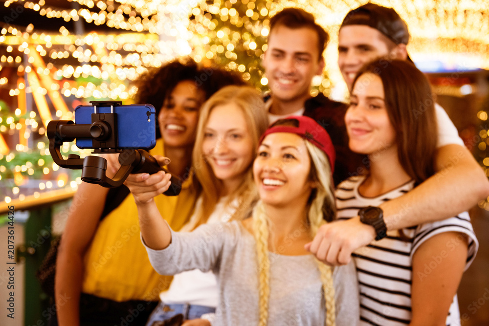 Obraz premium Friends capturing joyful moments with a selfie stick