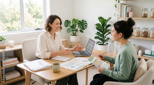 Two Women Collaborating In A Bright Office Setting Discussing Work