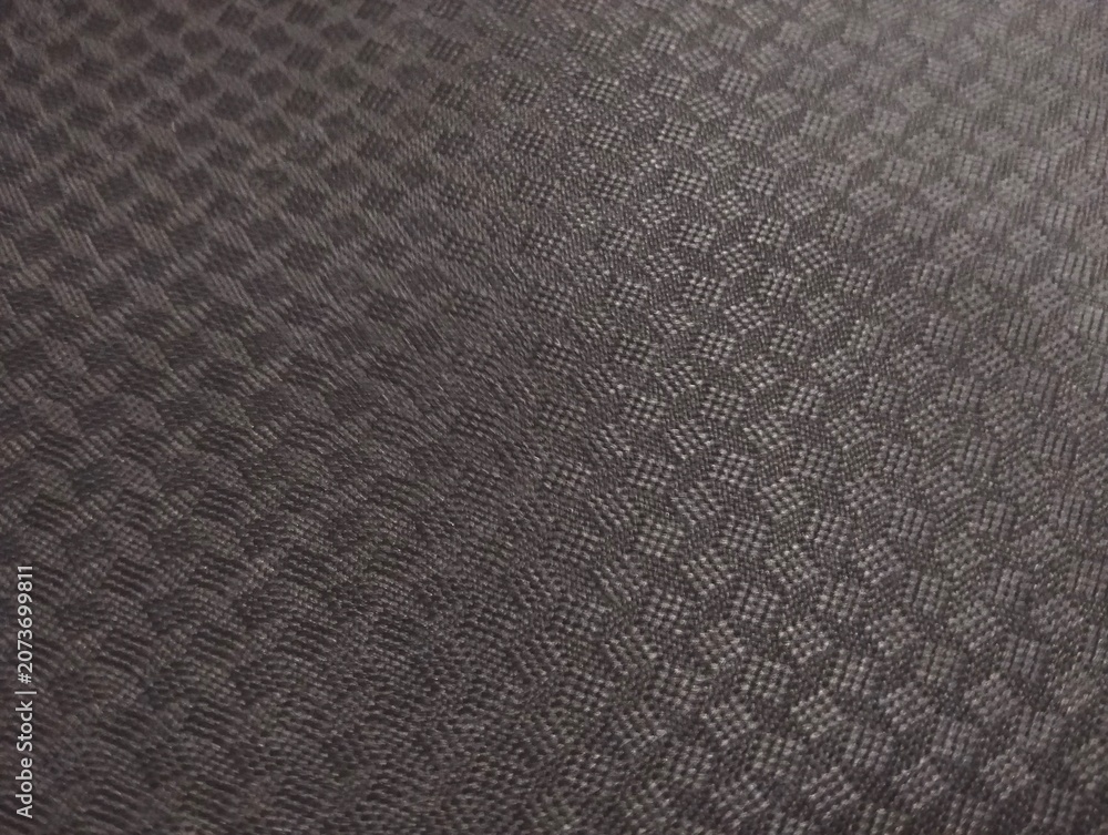 Fototapeta premium Close-up shot of a dark grey synthetic fabric material featuring an embossed geometric diamond grid pattern
