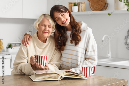 Young woman hugging elderly...