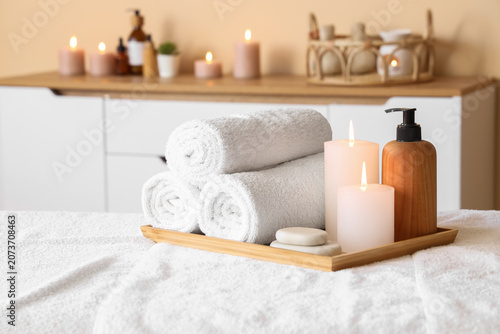 Fotografía Spa essentials with rolled towels and candles on wooden tray