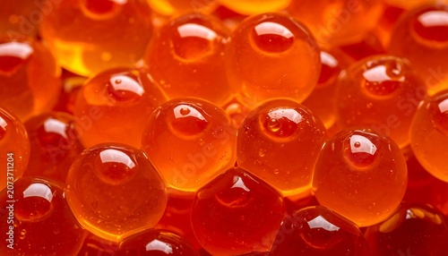 Macro close-up of vibrant orange and red translucent spheres, resembling glistening caviar or jelly pearls.