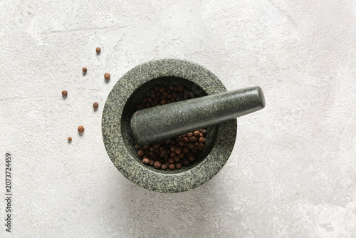 Konstfotografi Stone mortar and pestle with whole allspice on white surface