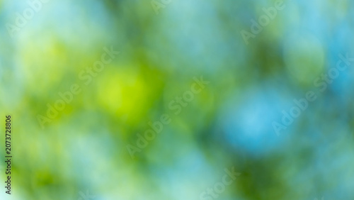 Soft green and blue bokeh creates an airy, tranquil background evoking summer...