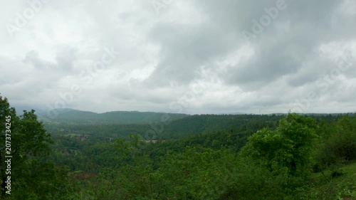 4K shot of dark clouds above the green hills of Saputara during the monsoon season in Gujarat, India. Scenic view of lush green forest during the monsoon season in Gujarat. Nature background.