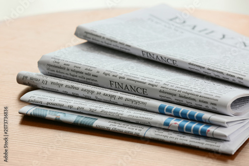 Obraz na płótnie Stack of folded finance newspapers on wooden table