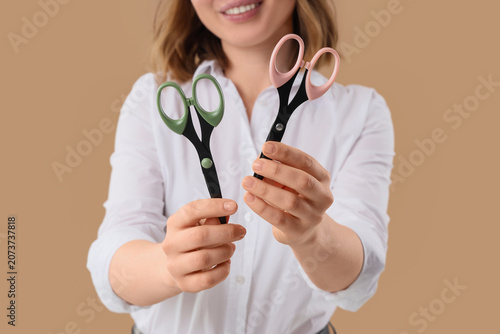 Konstfotografi Woman holding two pairs of scissors with colored handles