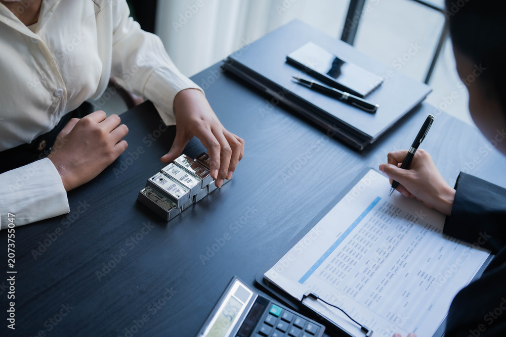 Fototapeta premium Two Asian businesswoman trading silver bar together in office. silver trading concept