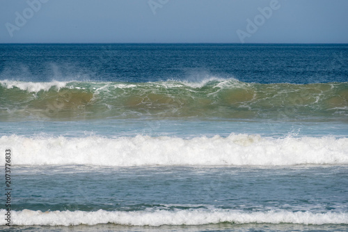 Ocean scene with layering waves rolling towards the shore