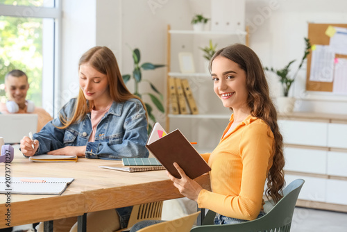 Female student studying at table in classroom