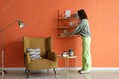 Young woman taking book fro...