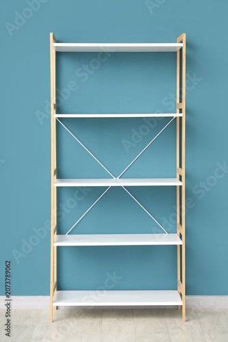 Bild auf Leinwand Empty white shelving unit near blue wall