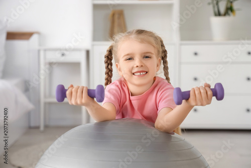 Sporty little girl with dum...