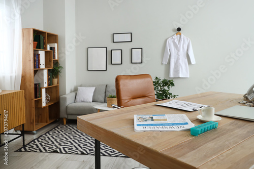 Interior of cabinet with shelving unit, hanging medical gown and laptop on wo...