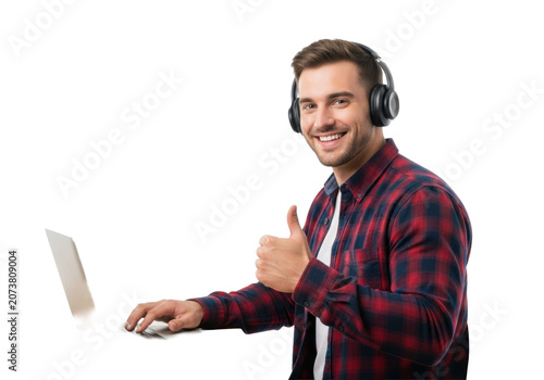 Young caucasian man, clean-cut, smiling, wearing a plaid shirt and black headphones, giving a confident thumbs up at a wooden desk, transparent studio background with copy space. Concept of
