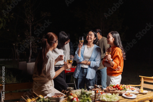 Canvas Print Group of friends enjoying outdoor night barbecue dinner party