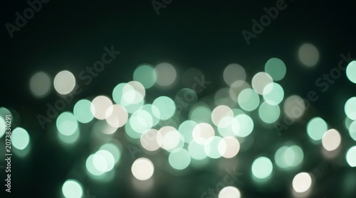 Blurry green and white bokeh lights on a dark background for creative design