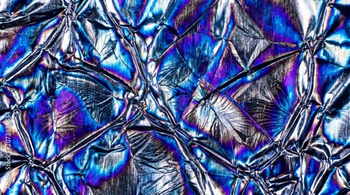 Vibrant iridescent bismuth crystal texture with intense blue purple gold metallic reflections macro