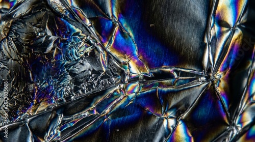 Dramatic iridescent crystalline structure with electric blue purple and warm gold highlights abstract
