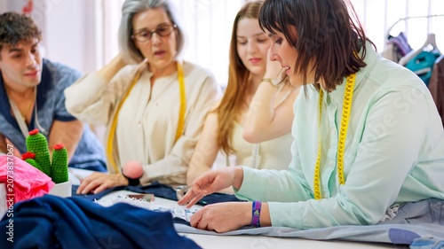 Принти на полотні Tailor instructing students crafting fabric in sewing workshop class