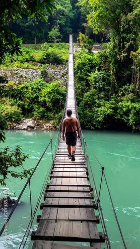 Man walking on a suspension bridge.