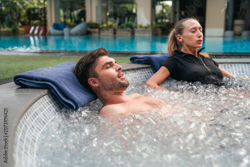 Obraz na plátne Couple doing ice bath at a luxury wellness retreat, practicing deep breathing to
