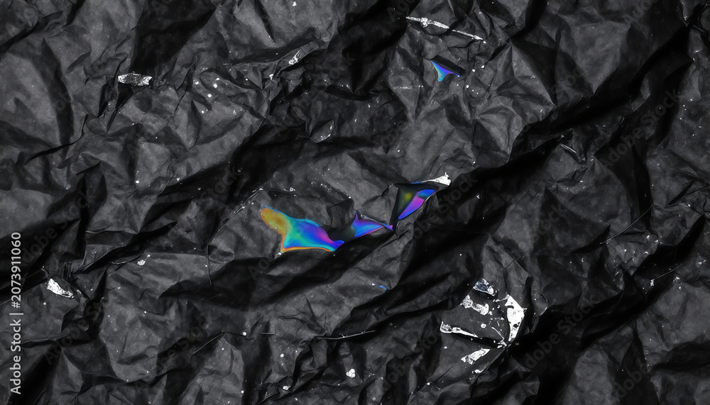 Naklejka premium Black crumpled paper texture with holographic iridescent tears