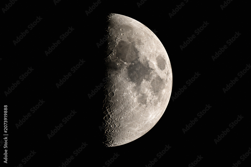 Fototapeta premium A crescent moon is visible against the blackness of space.