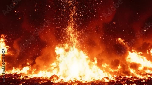 Intense orange flames erupt from a burning ground at night