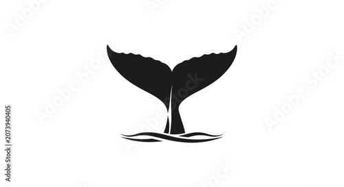 Foto Black whale tail fluke silhouette breaching ocean surface.