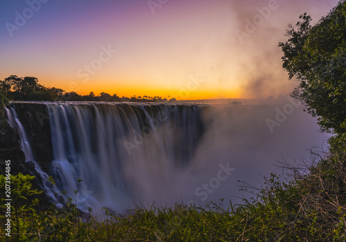 Konstfotografi Majestic Victoria Falls with golden sunset and rare lunar rainbow moon bow at ni
