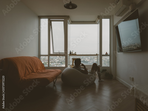 Minimalist living room with sofa and window view in urban Thai apartment interior in a quiet minimalist Thai apartment with natural daylight