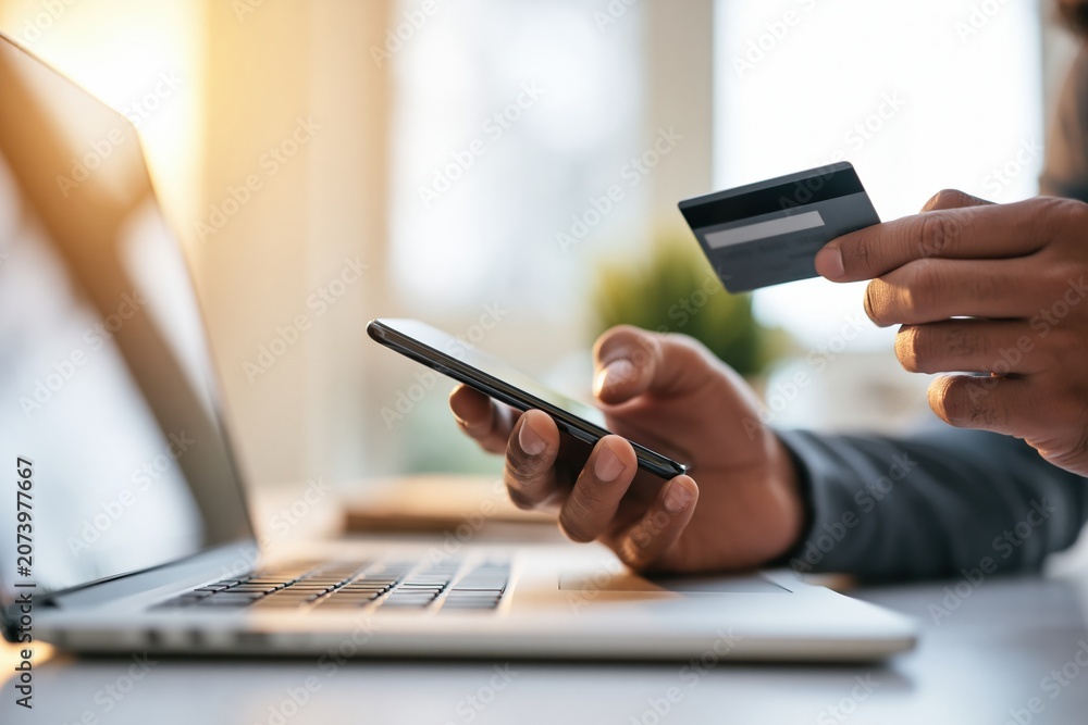 Fototapeta premium Businessman paying online with credit card and smartphone