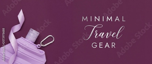 Purple collapsible silicone water bottle with carabiner and ribbon on violet background, flat lay composition of minimal travel gear for active lifestyle hydration and outdoor adventure mockup.