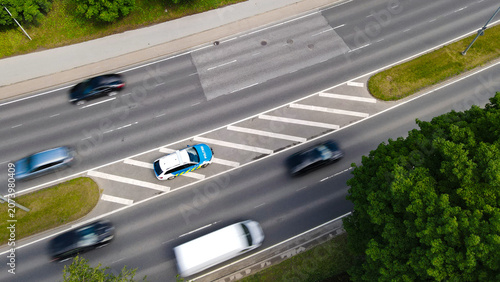 Fotografie Estonian police car parked alongside a busy urban highway, monitoring speed limi