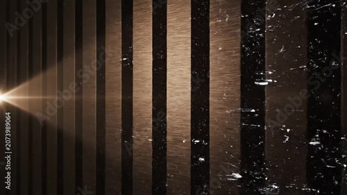 Stripes of textured dark material stand in a vertical row while light beams across the surface.