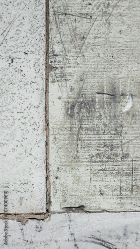 Weathered concrete surface showing scratches, stains and structural wear forming abstract industrial texture background