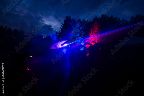Картината върху платно Spectacular laser light show at outdoor music festival in the night forest