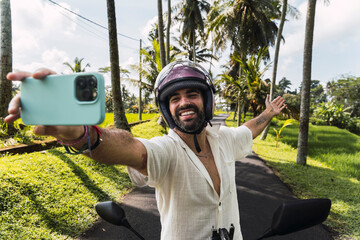 Tourist taking selfie on motorbike during tropical Bali adventure