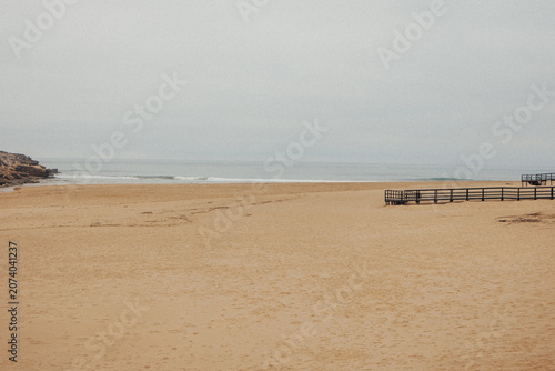 Принти на полотні Empty beach stretches under soft, hazy sky
