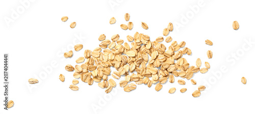 Scattered oat flakes on a clean white background.  Top view of oat flakes isolated.