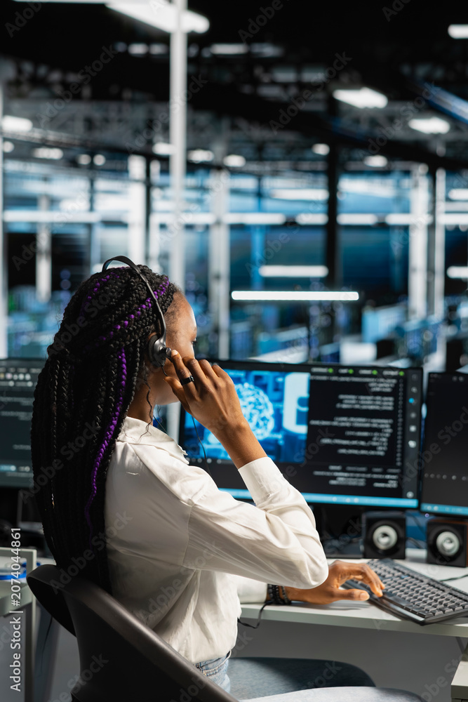 Fototapeta premium IT expert provides technical support from a data center using a headset while troubleshooting client server issues.