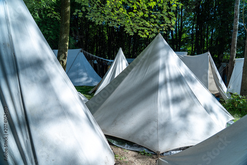 Tableau sur toile Historical encampment showing traditional white canvas tents in a forest setting