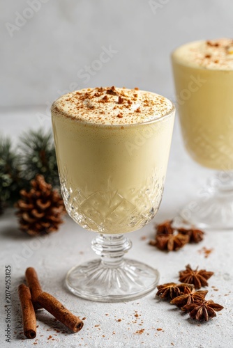 Creamy eggnog christmas drink with cinnamon and star anise spices, vertical
