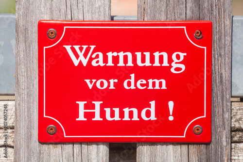 Foto Rotes Schild Warnung vor dem Hund, bissiger Hund an einem Gartenzaun, Deutschlan