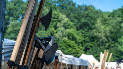 Obraz na plátně Displaying historical axes and medieval weaponry in an outdoor reenactment camp